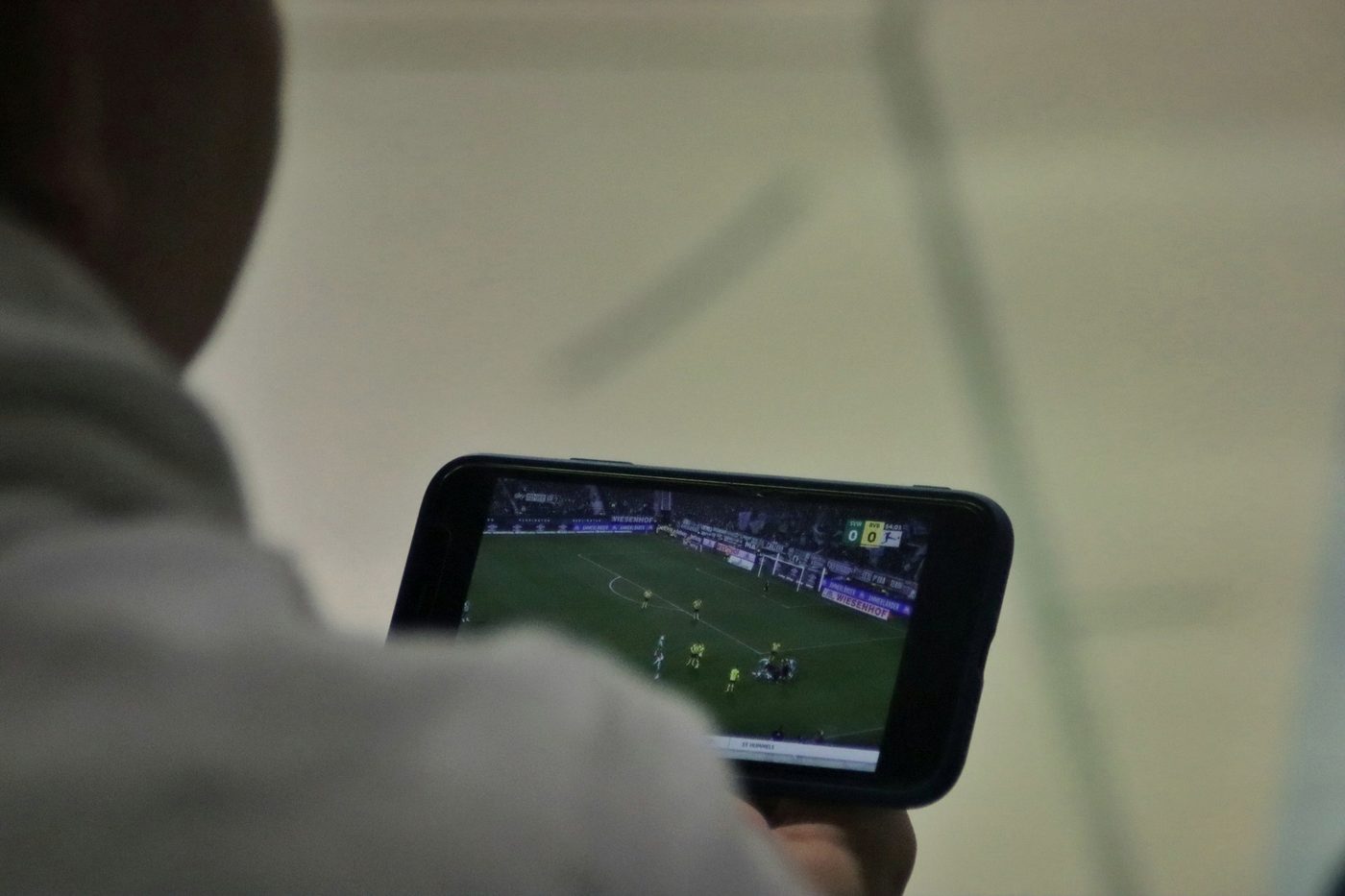 A person watching a football match on a phone.