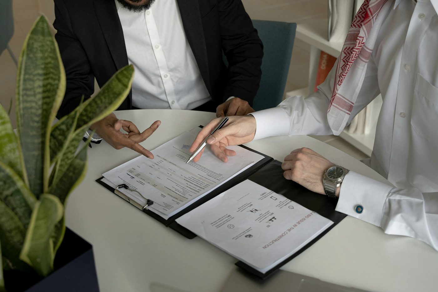 Two businessmen going through company documents at a table.